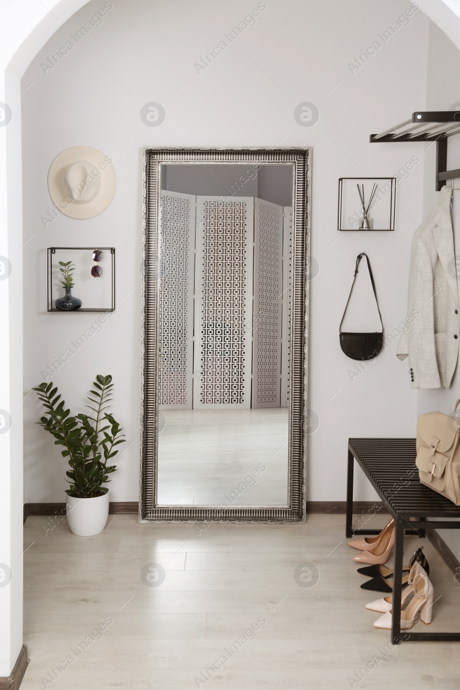 Photo of Modern hallway interior with large mirror and houseplant