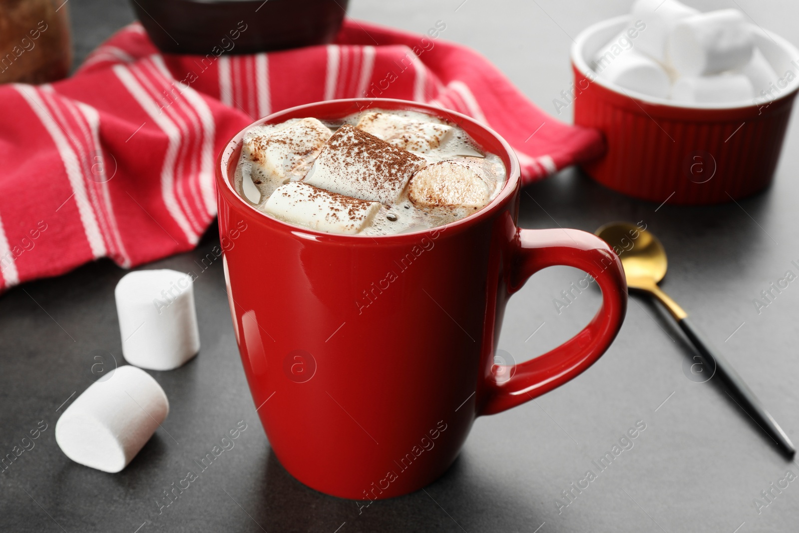 Photo of Delicious hot chocolate with marshmallows and cocoa powder on grey table, closeup