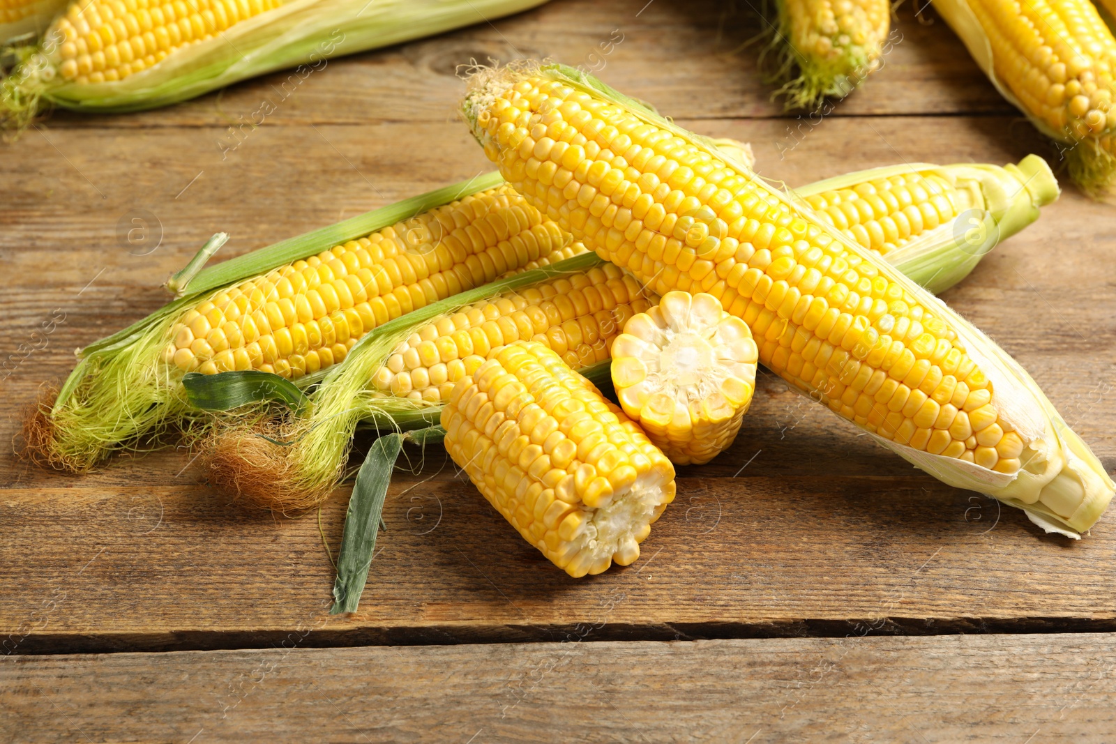 Photo of Tasty sweet corn cobs on wooden table