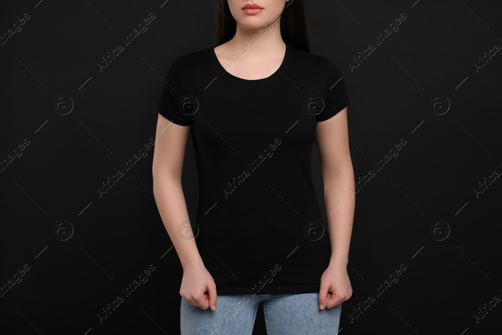 Photo of Woman wearing black t-shirt on dark background, closeup
