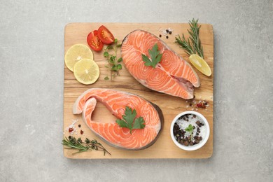 Fresh salmon and ingredients for marinade on light grey table, top view