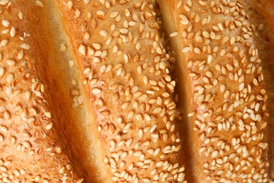 Photo of Tasty bread with sesame seeds as background, closeup