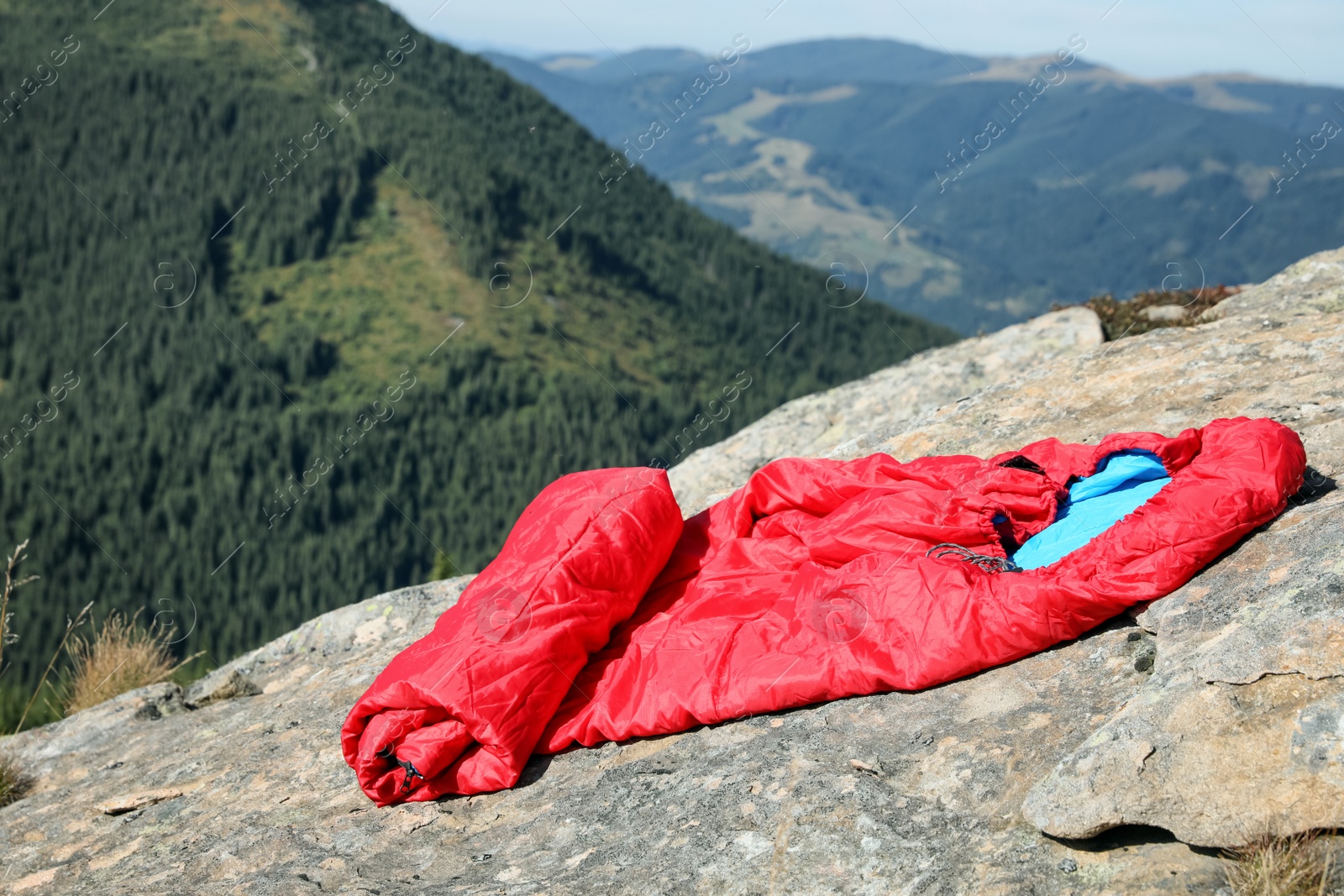 Photo of Sleeping bag on mountain peak, space for text