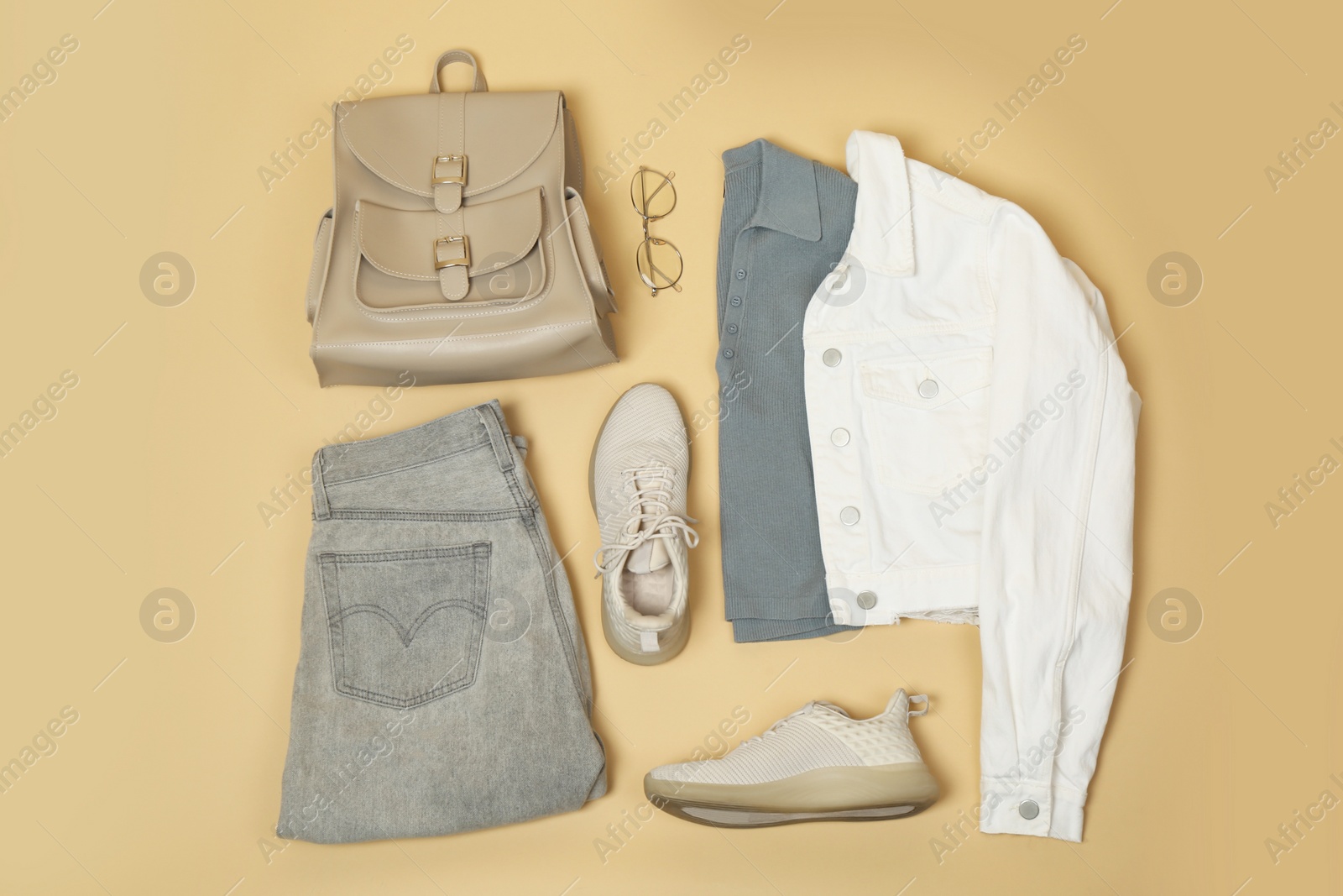 Photo of Set of stylish clothes and accessories on beige background, flat lay