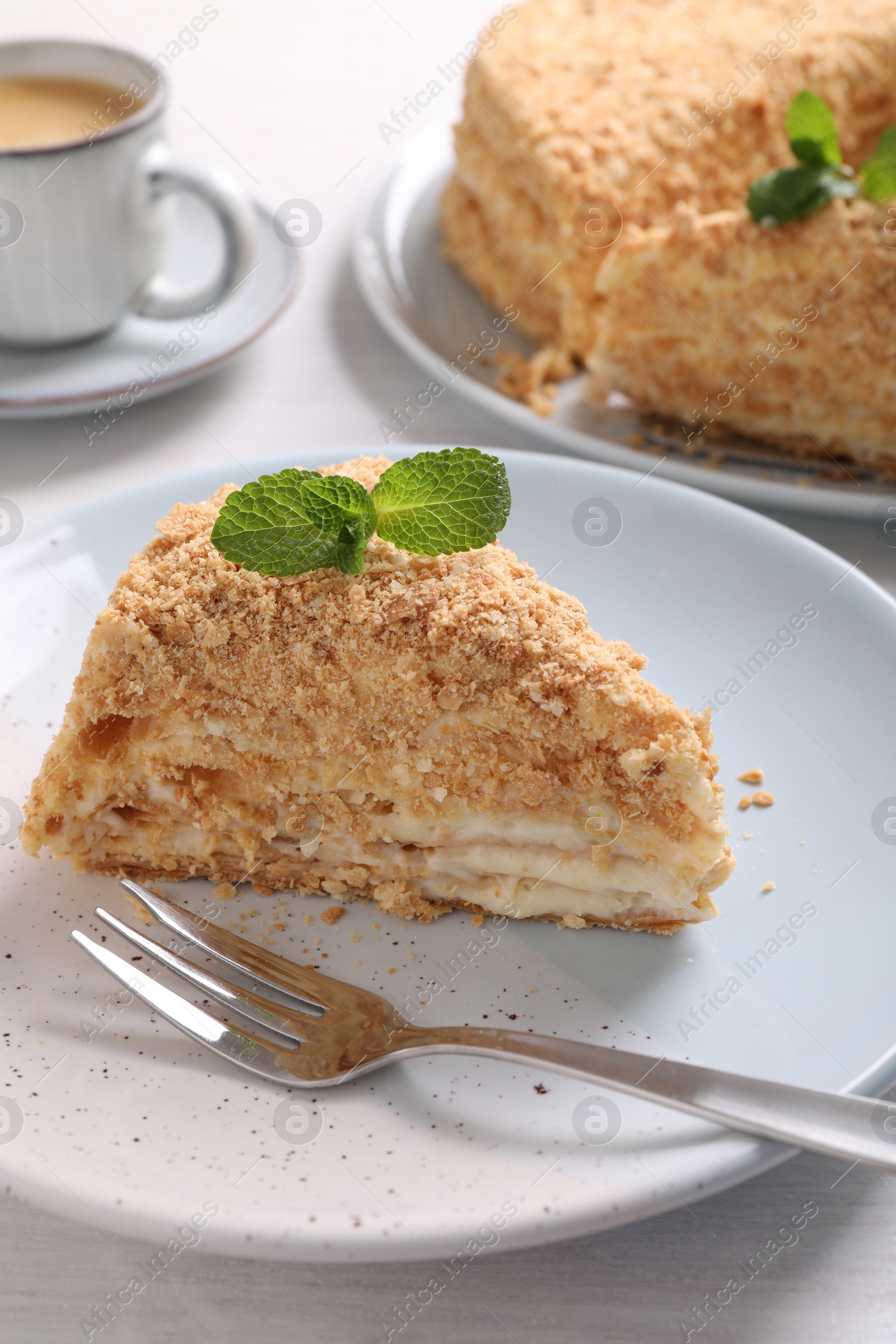 Photo of Piece of delicious Napoleon cake served on table, closeup