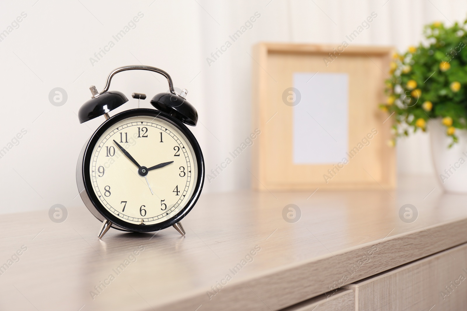 Photo of Alarm clock on table in living room, space for text. Time of day