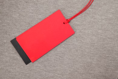Photo of Red tag on brown garment, top view. Space for text