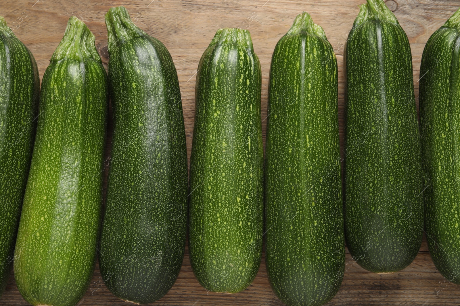 Photo of Raw ripe zucchinis on wooden table, flat lay