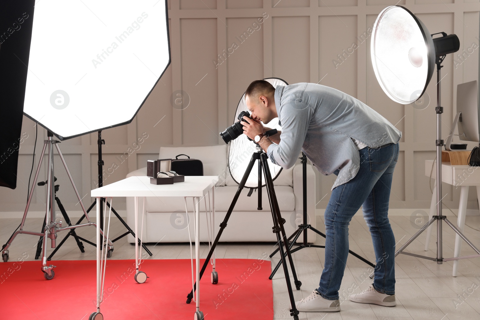 Photo of Professional photographer taking picture of expensive wristwatches in studio