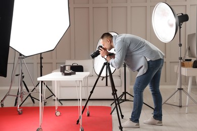 Photo of Professional photographer taking picture of expensive wristwatches in studio