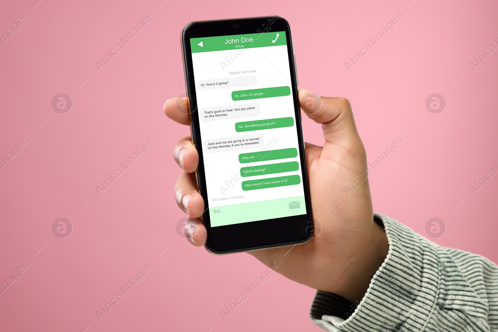 Image of Man texting with friend using messaging application on smartphone against pink background, closeup