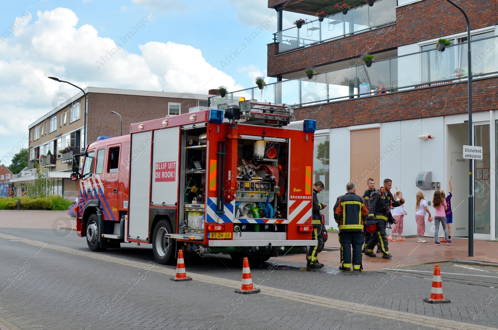 Photo of Oude Pekela, Netherlands - June 14, 2022: Modern red fire truck near building on city street