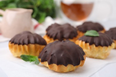 Photo of Delicious profiteroles with chocolate spread on table, closeup