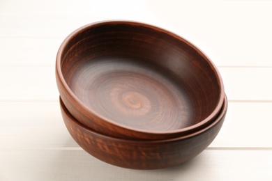 Photo of Beautiful clay bowls on white wooden table