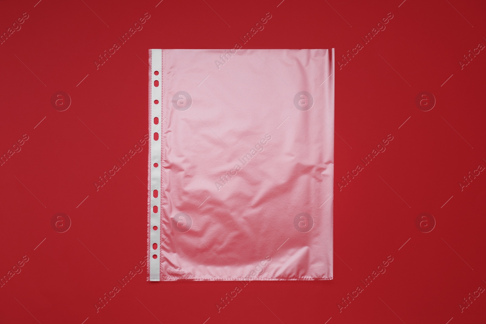 Photo of Punched pocket on red background, top view