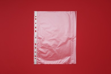Photo of Punched pocket on red background, top view