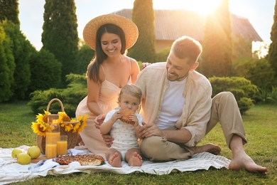 Photo of Happy family having picnic in garden on sunny day