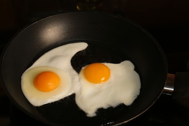 Photo of Cooking eggs for breakfast in frying pan on cooktop
