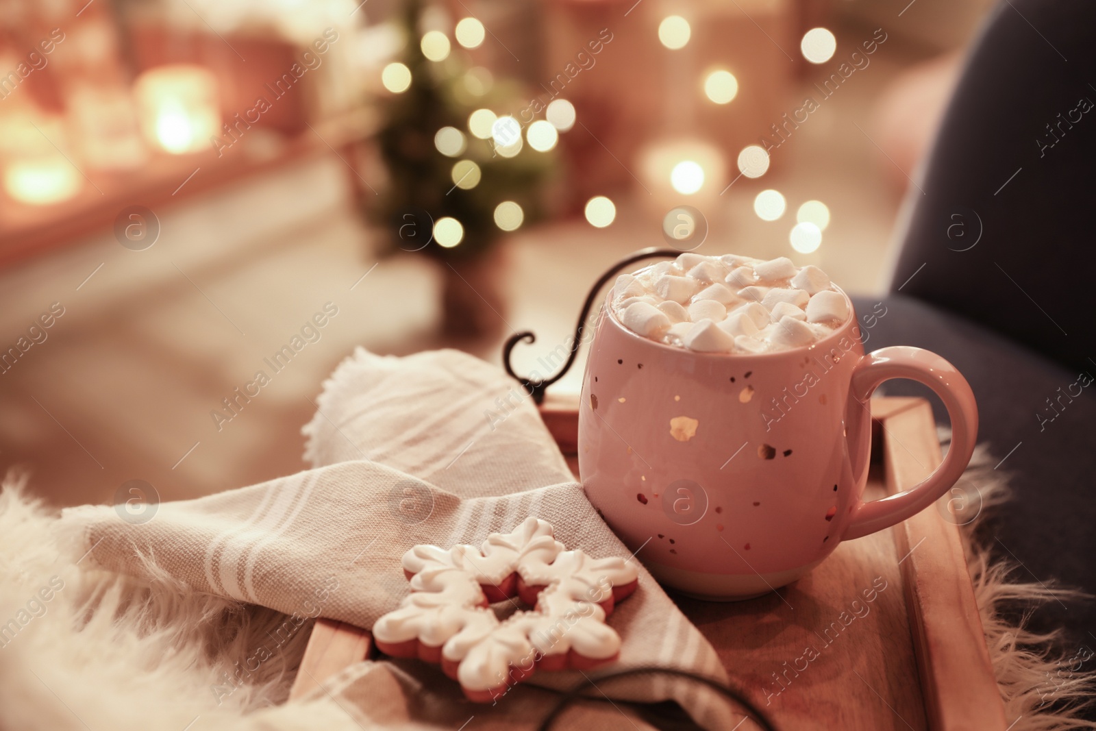 Photo of Cup of hot drink with marshmallows and cookie on wooden tray indoors. Christmas atmosphere