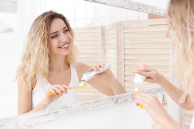 Young woman brushing her teeth in bathroom