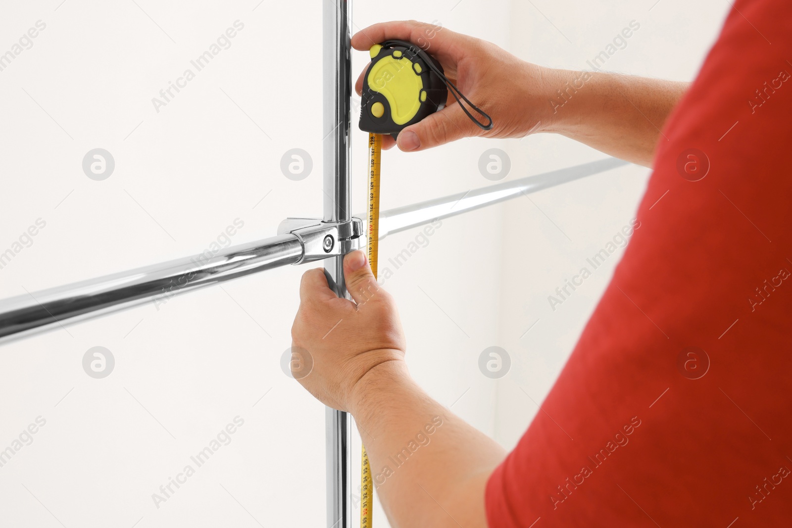 Photo of Worker measuring metal pipes for installation, closeup