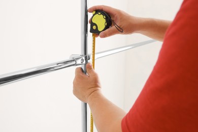 Worker measuring metal pipes for installation, closeup