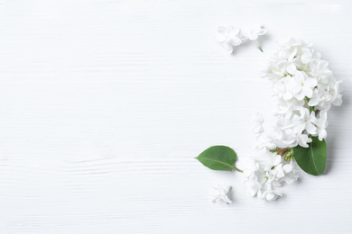 Photo of Beautiful lilac blossom on white wooden background, flat lay. Space for text
