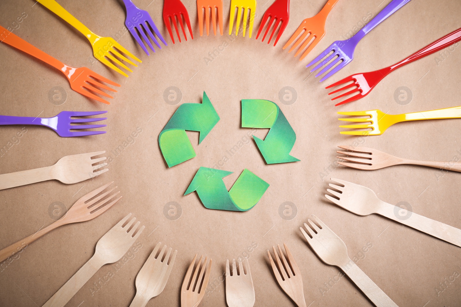 Photo of Recycling symbol, plastic and wooden forks on beige background, flat lay