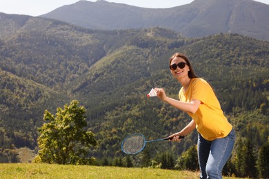 Photo of Woman playing badminton in mountains on sunny day. Space for text