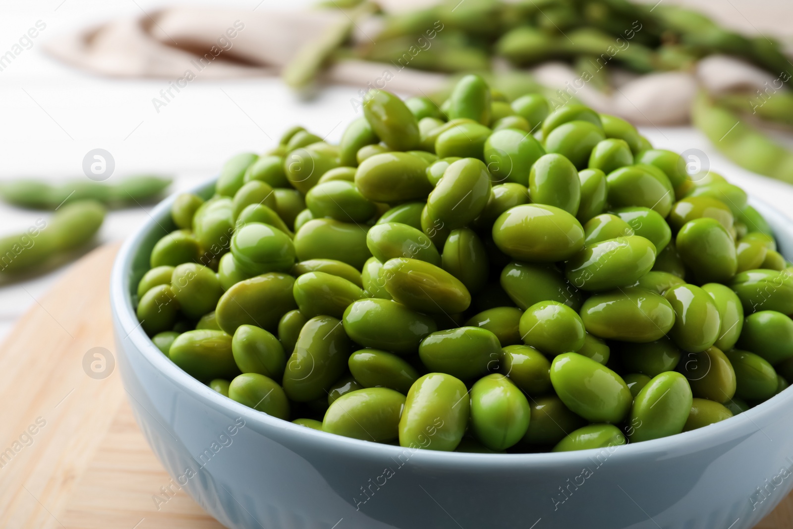 Photo of Bowl of delicious edamame beans on table, closeup