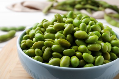 Photo of Bowl of delicious edamame beans on table, closeup