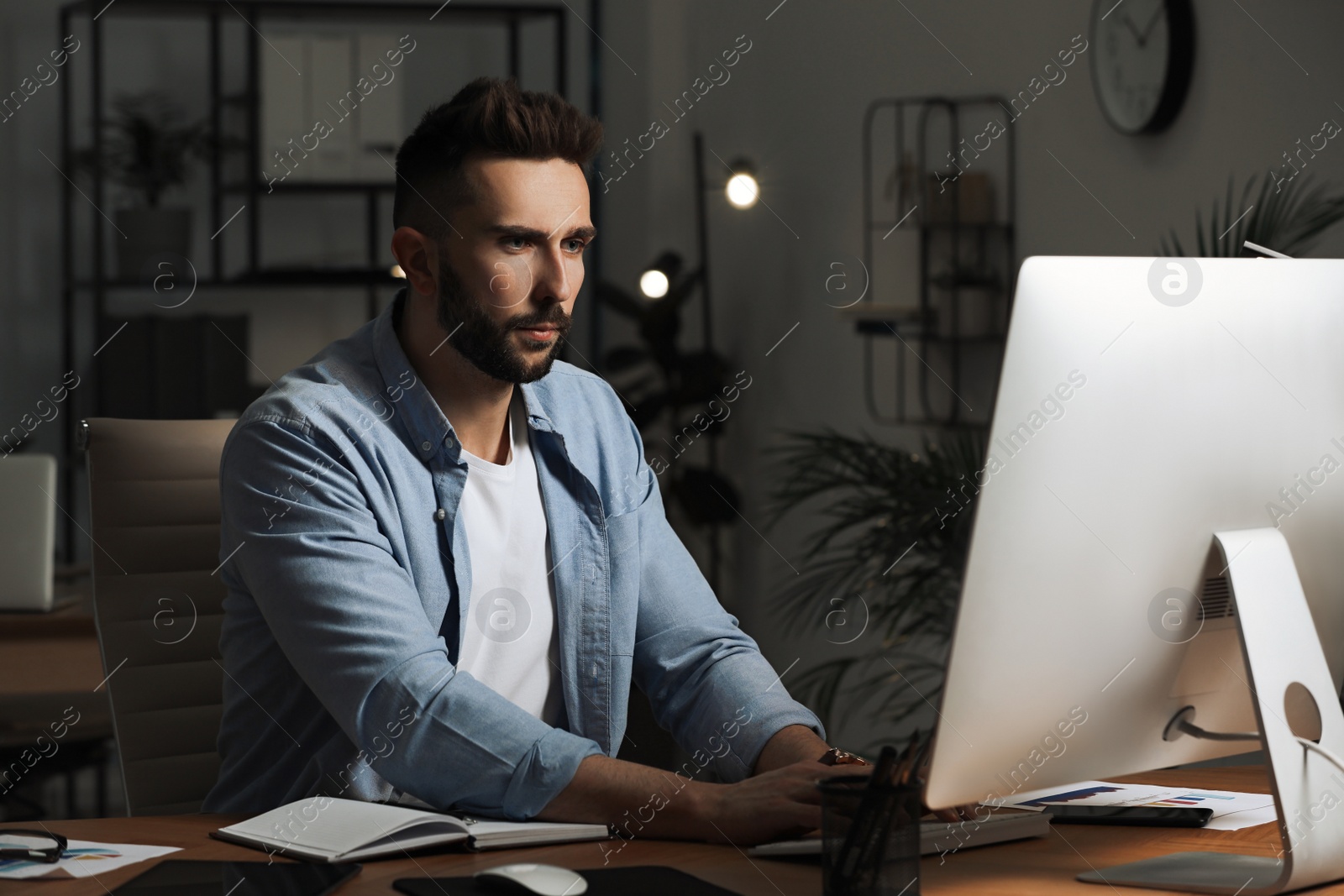 Photo of Man working on computer at table in office