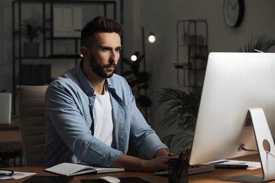 Photo of Man working on computer at table in office