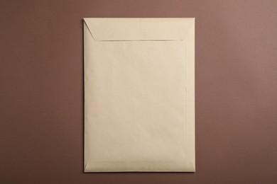 Photo of Kraft paper envelope on brown background, top view