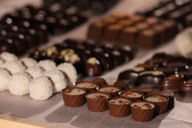 Photo of Many delicious chocolate candies on table, closeup. Production line