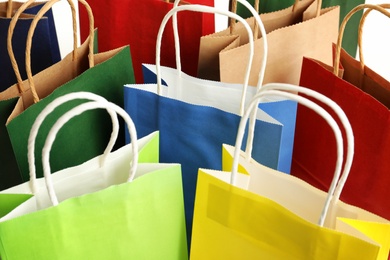 Photo of Colorful paper shopping bags as background, closeup