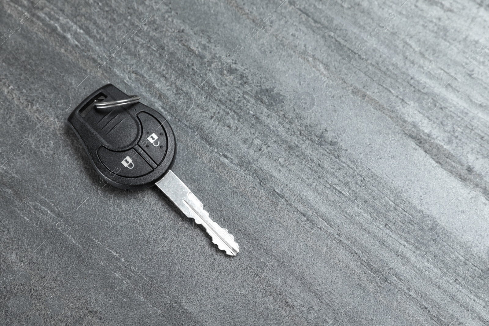 Photo of Car key on grey background, top view with space for text