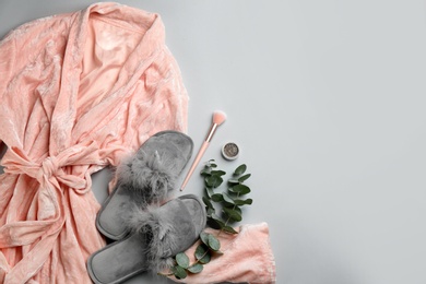 Photo of Flat lay composition with fluffy slippers and robe on grey background, space for text. Comfortable home outfit