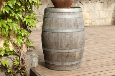 Photo of Traditional wooden barrel on street outdoors. Wine making