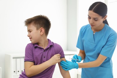 Photo of Doctor vaccinating little child in modern clinic