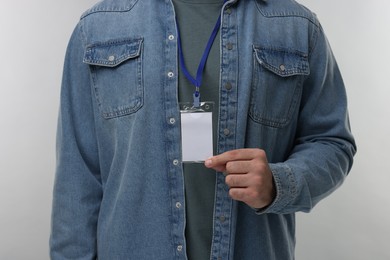 Man with blank badge on grey background, closeup