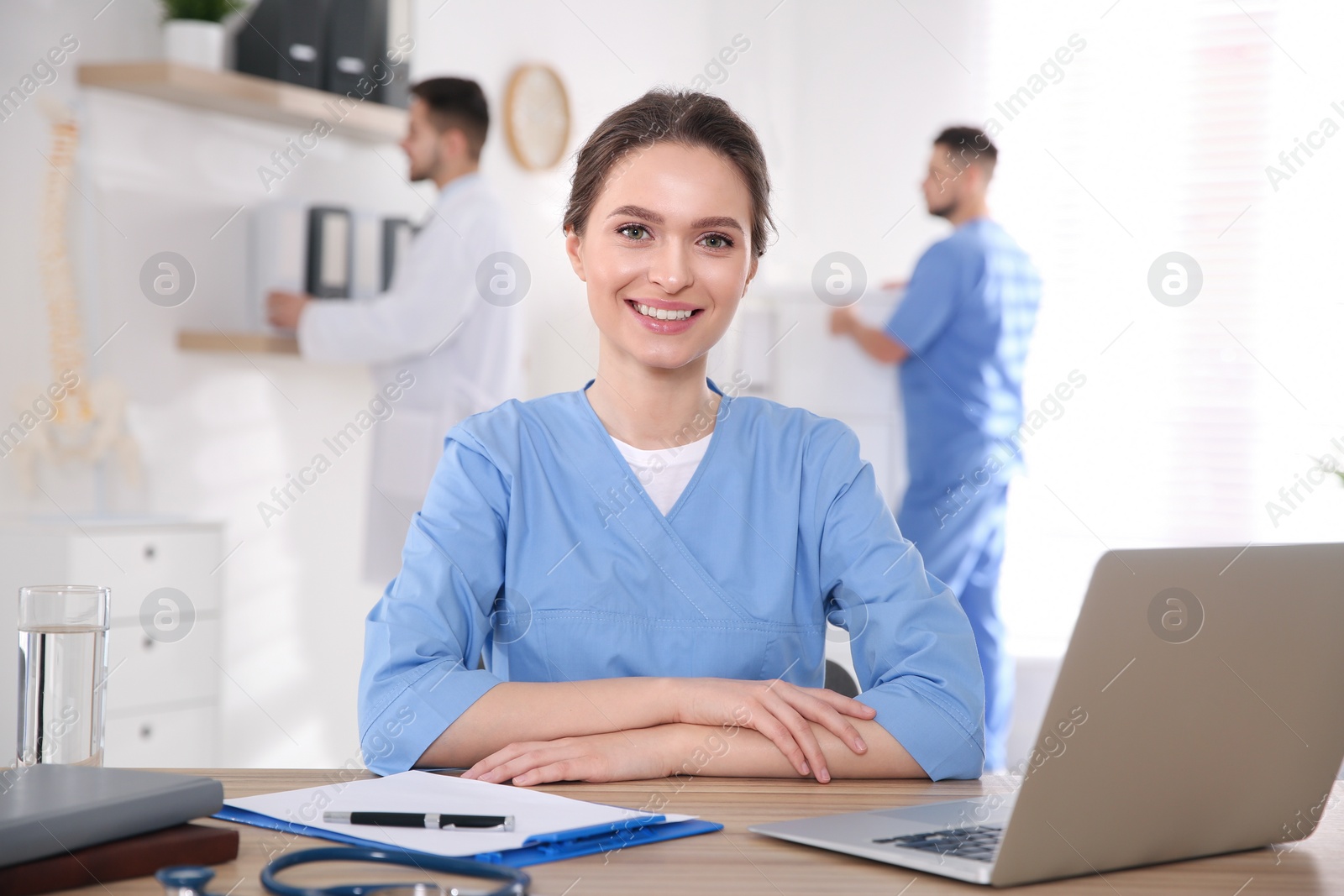 Photo of Portrait of female doctor at table in modern clinic