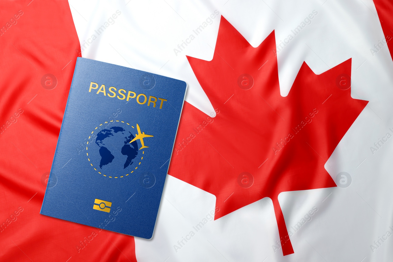 Image of Blue passport and flag of Canada, top view