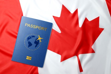 Image of Blue passport and flag of Canada, top view