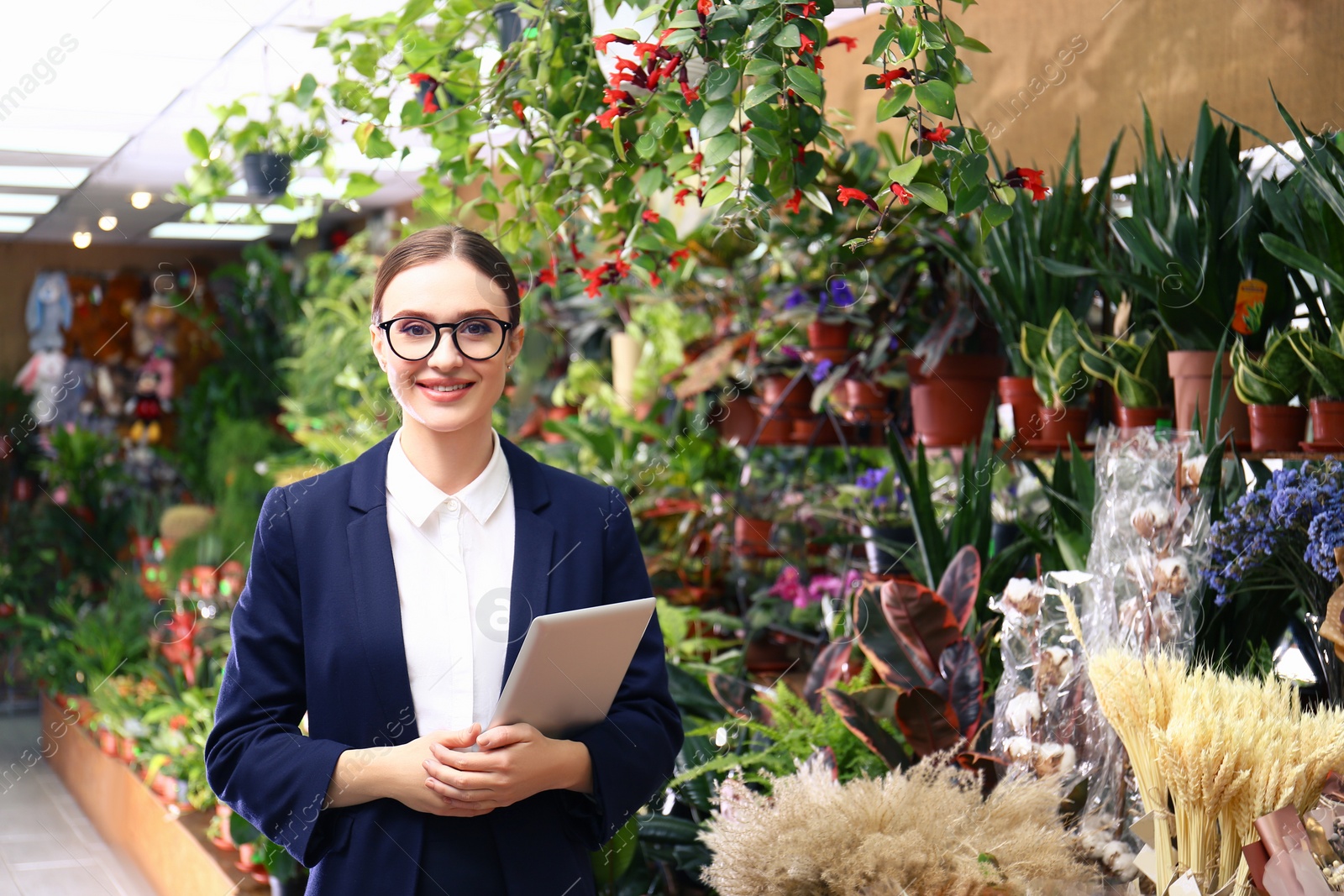 Photo of Female business owner with tablet in flower shop