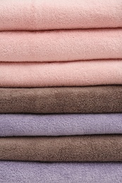 Stack of folded soft colorful towels as background