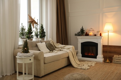 Fireplace in room with Christmas decorations. Interior design