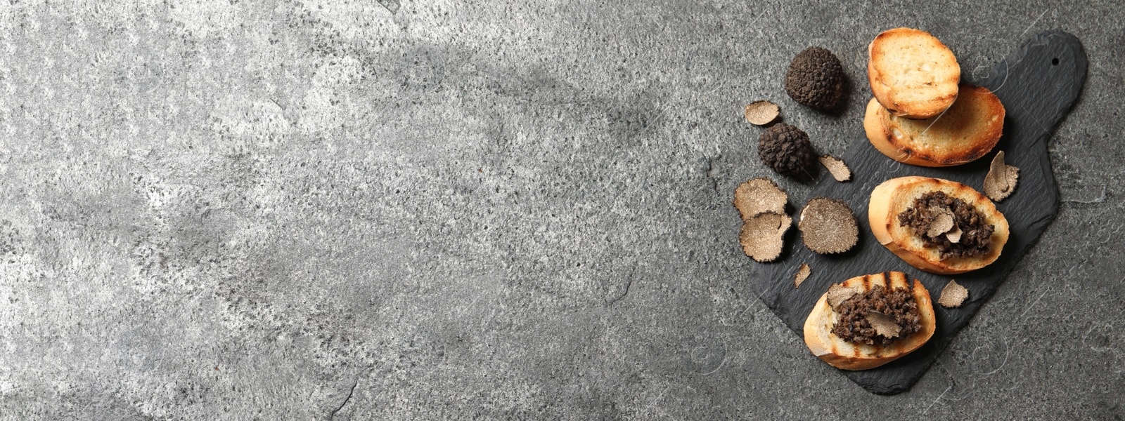 Image of Delicious bruschettas with truffle sauce on grey table, flat lay with space for text. Banner design