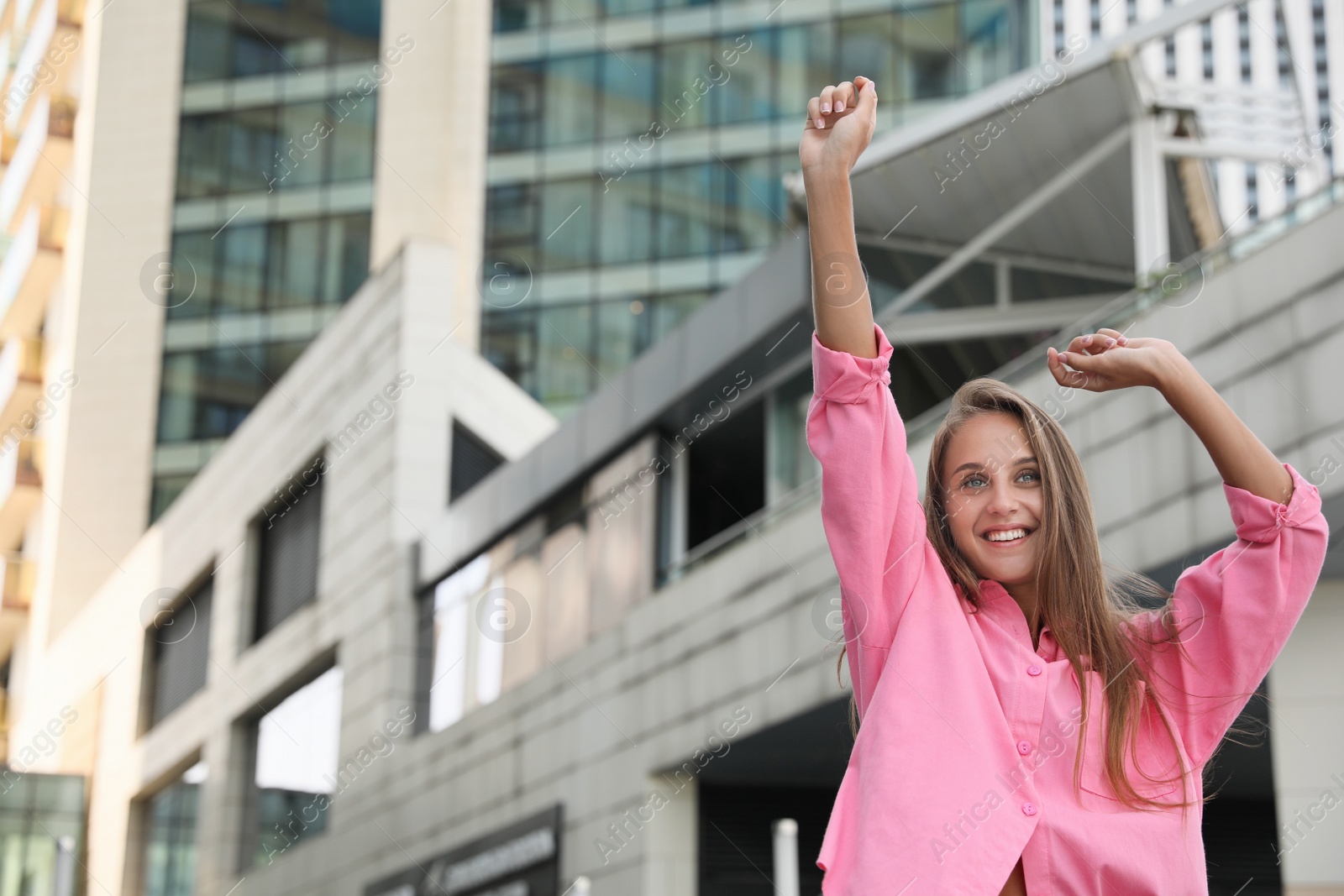 Photo of Beautiful young woman in stylish shirt on city street, space for text