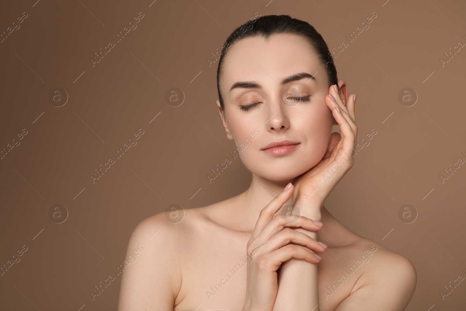 Photo of Portrait of beautiful young woman on brown background. Space for text